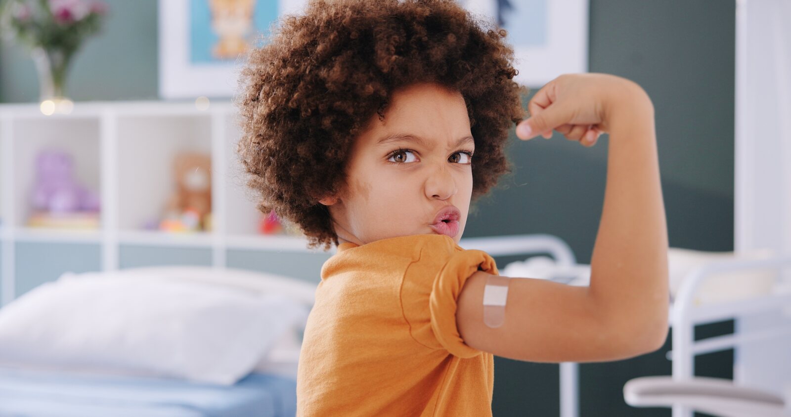 A child showing a bandage after a vaccination